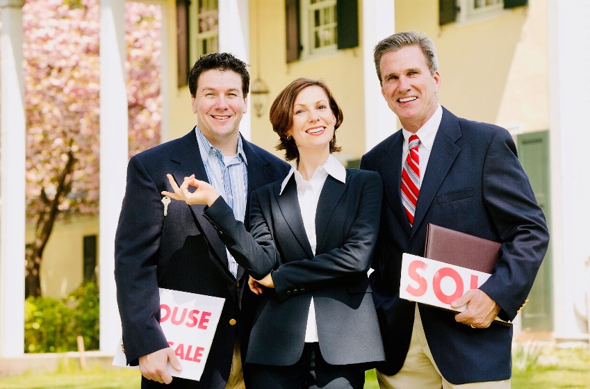 A group of people standing next to a person in a suit and tie

Description automatically generated